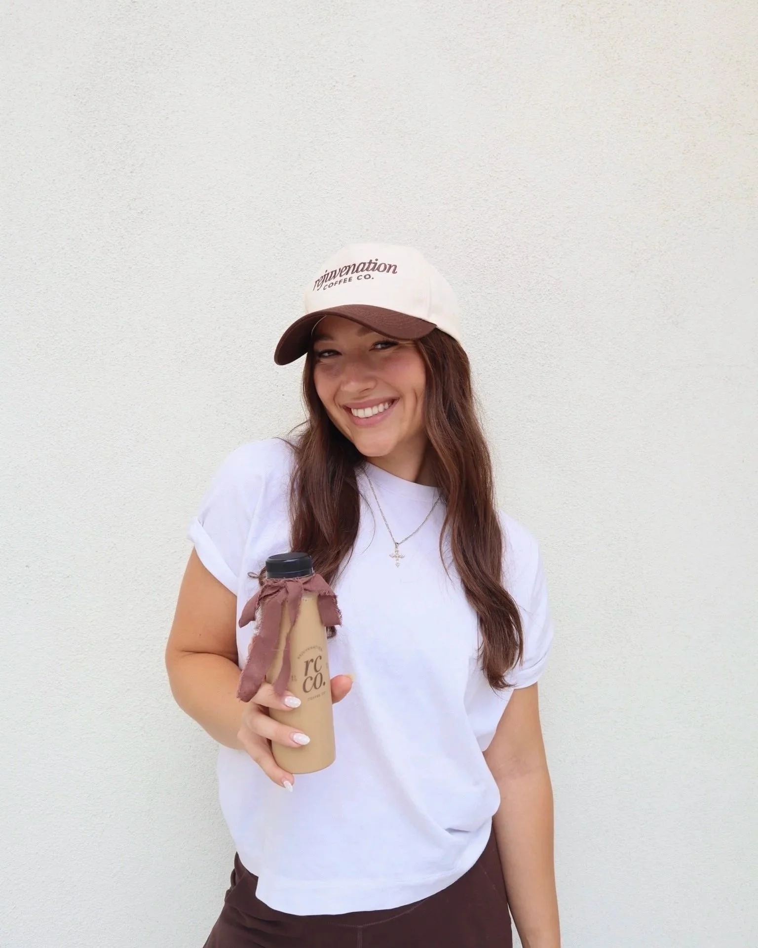 Rejuvenation Coffee Owner holding a bottled latte for a Pilates Event in North Scottsdale Arizona.