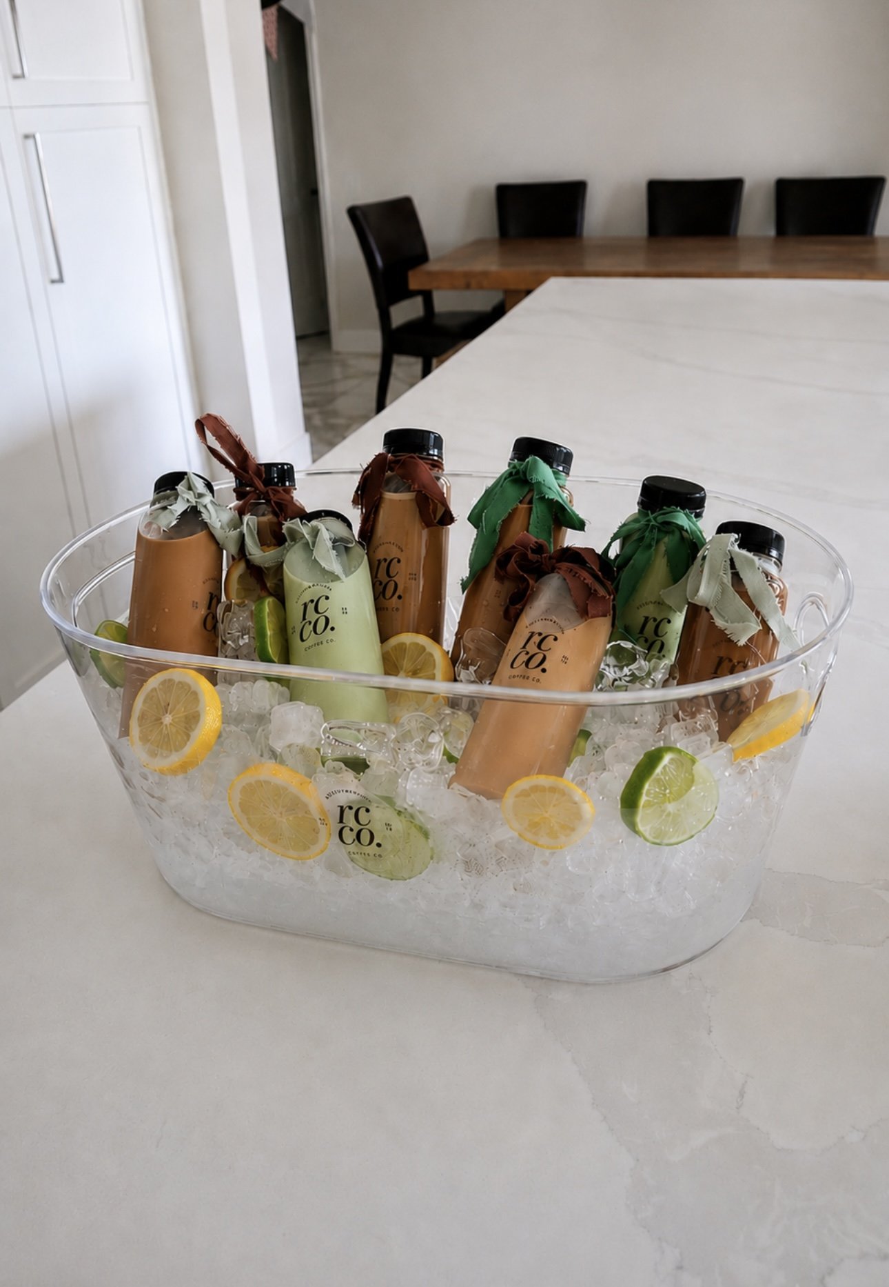 A clear plastic bowl filled with ice, lemon and lime slices, and several bottled lattes for a Pilates event in Cave Creek Arizona.