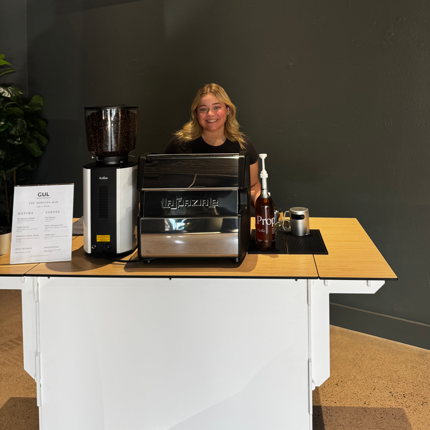 Professional Barista smiling behind our Rejuvnation Coffee coffee cart at an Event in North Scottsdale.