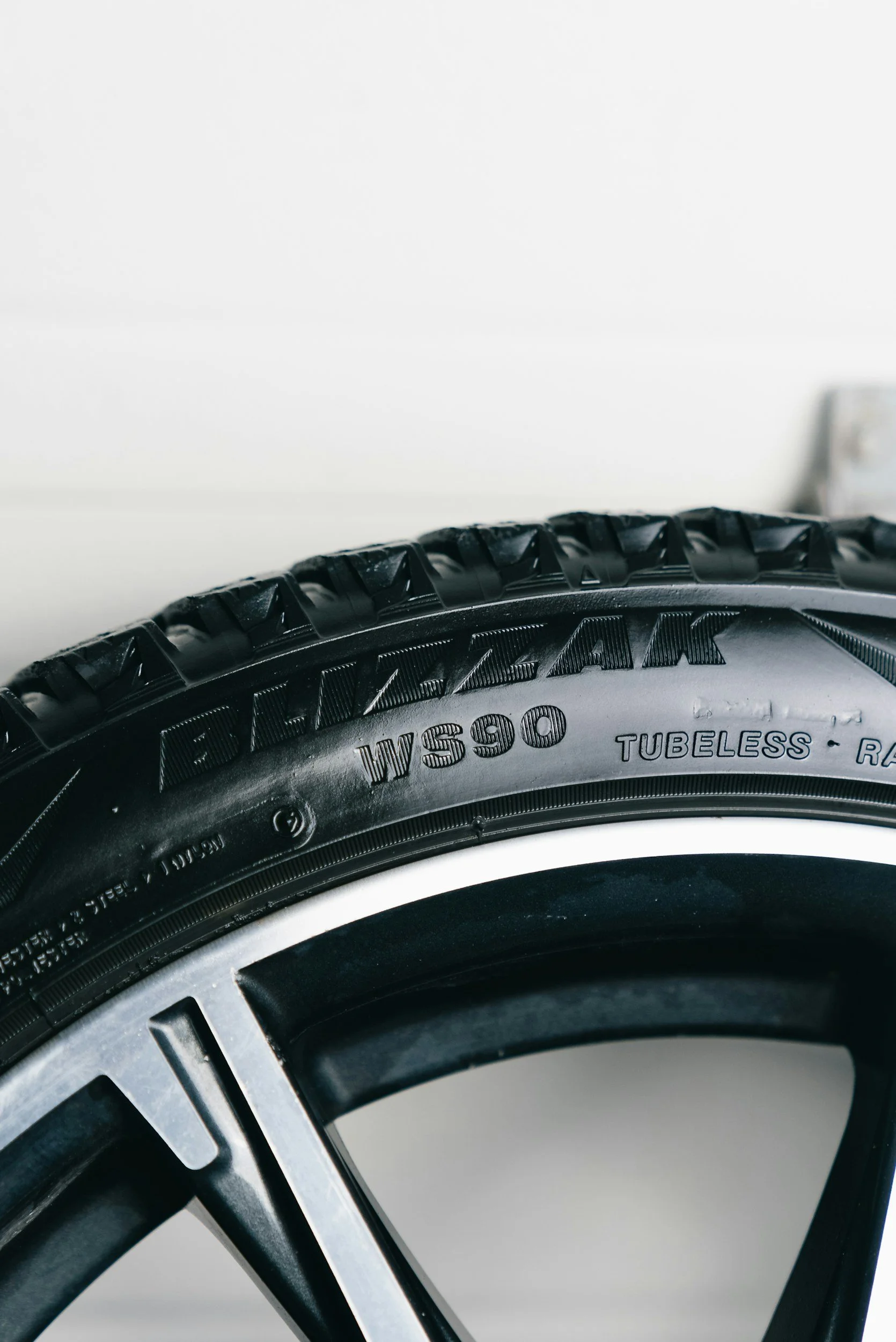 Close-up of a black bicycle tire with the brand name 'MAXXIS' and model 'W90' visible, mounted on a bicycle rim.