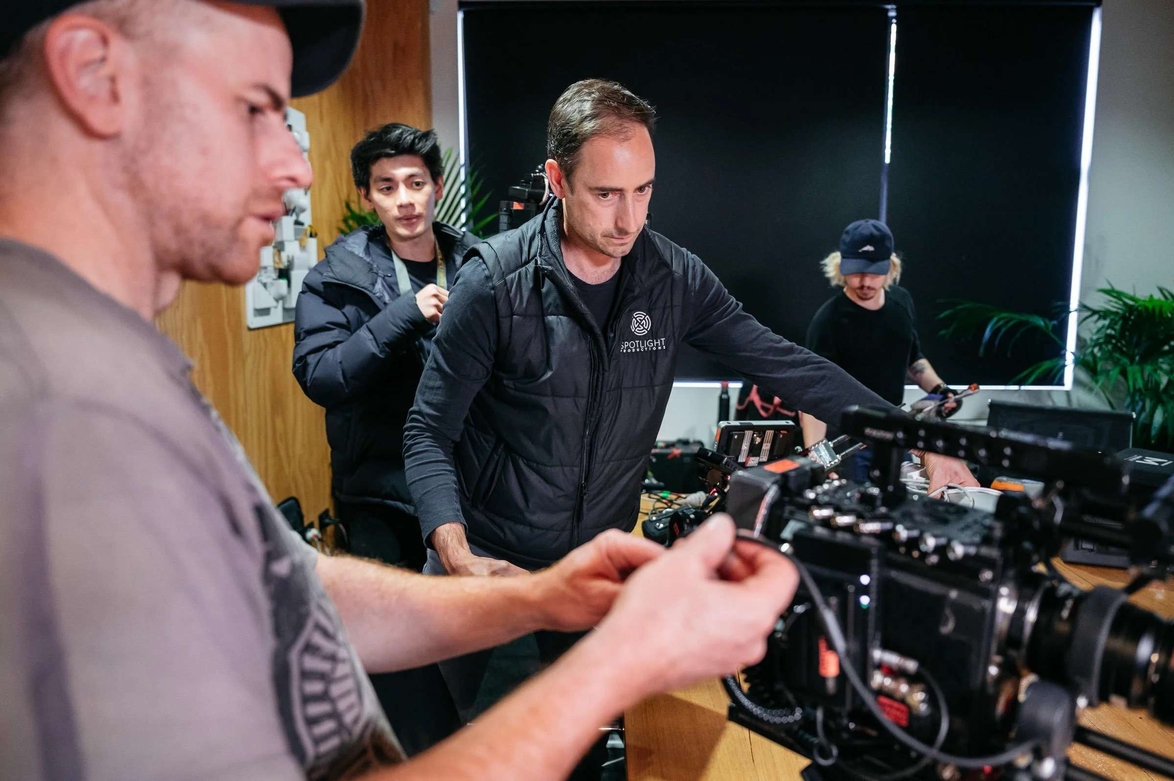 A group of people working together on a film or video production, with equipment and monitors on a table.