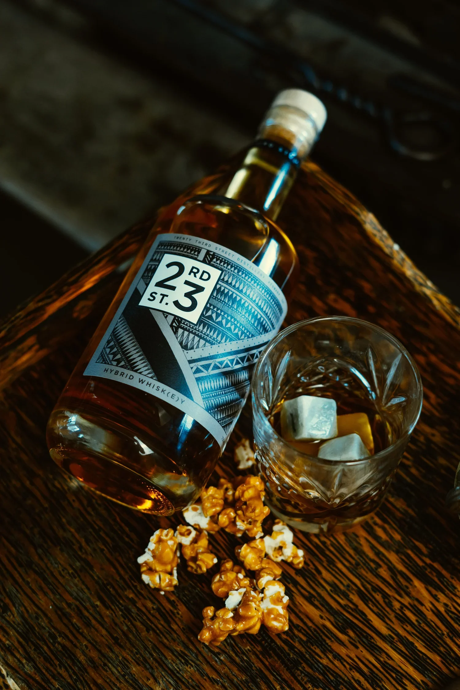 a bottle of whisky with a glass and popcorn