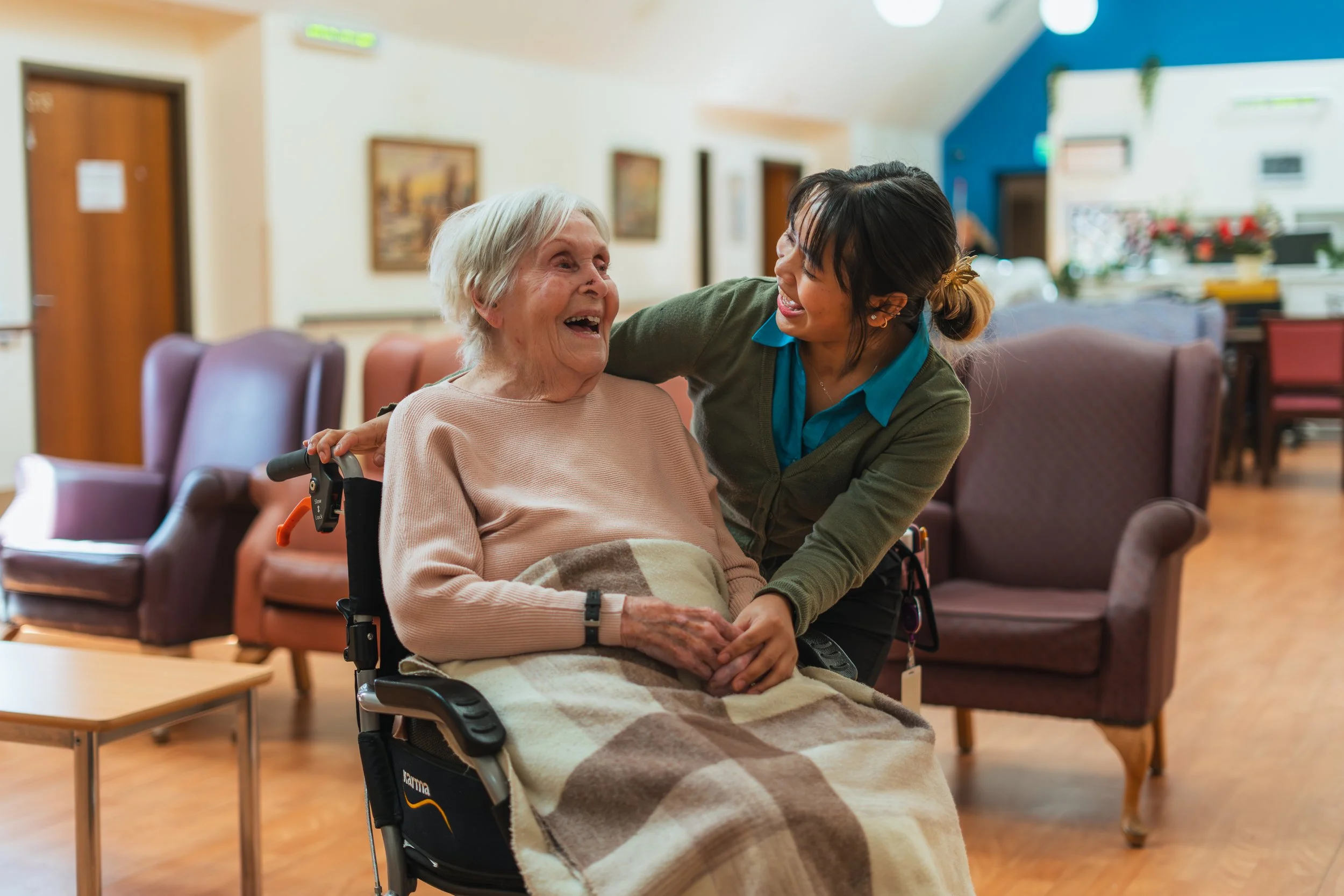 a aged care worker and an elderly woman smiling at each other