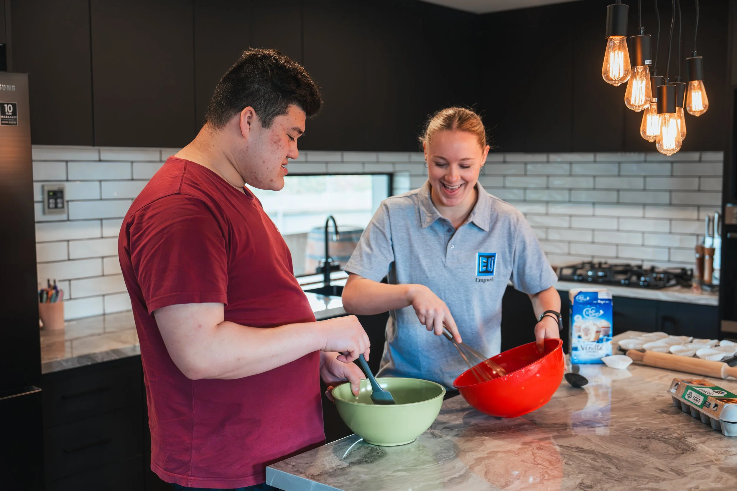 a female disability support worker baking with the male client