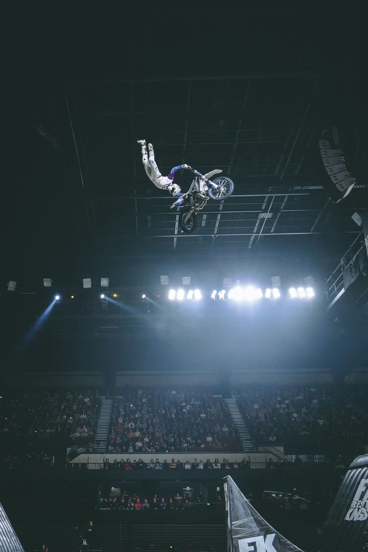 Professional Freestyle MX rider performing a trick in the air after jumping a ramp at a Freestyle Kings event