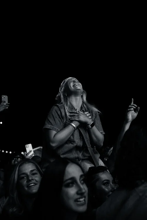 women sitting on shoulders in a crowd who are signing, smiling and dancing at a music festival in McLaren Vale, South Australia