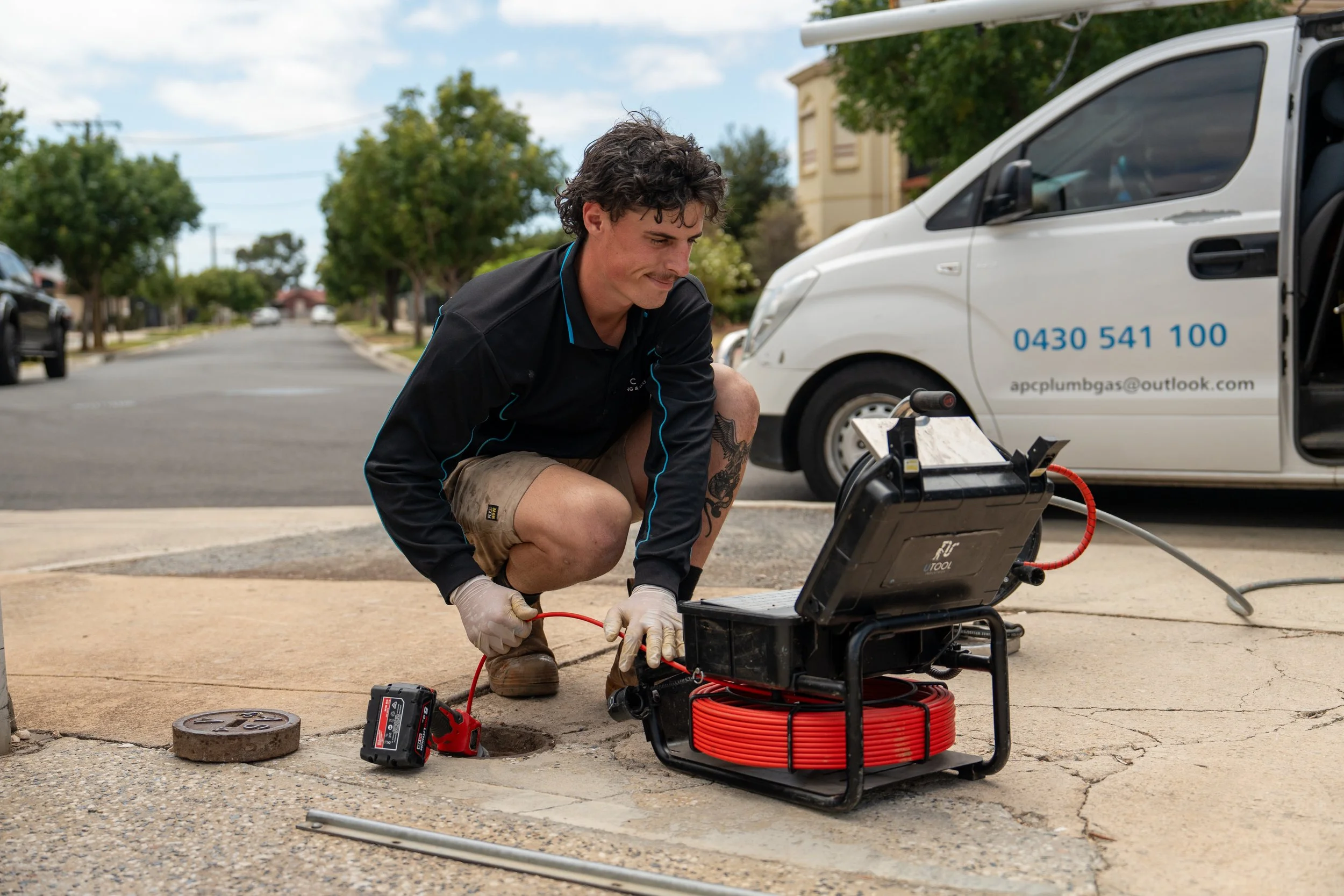 A plumbing conducting a CCTV inspection of a drain