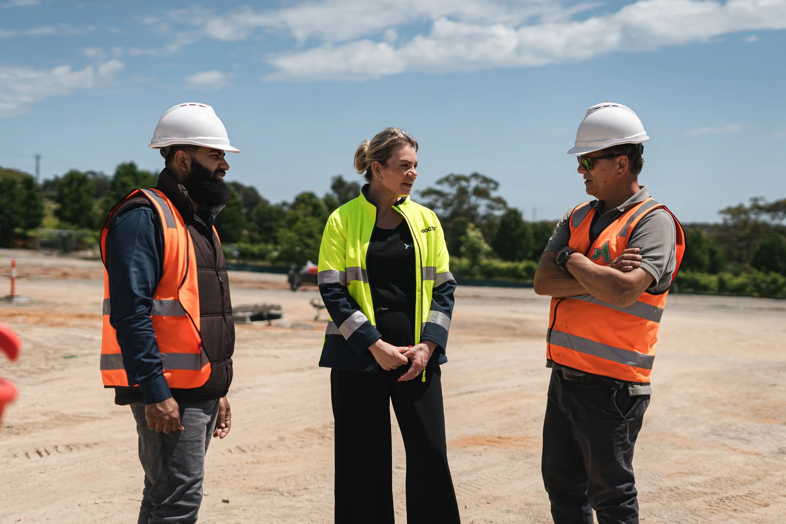 Three people talking on a construction site