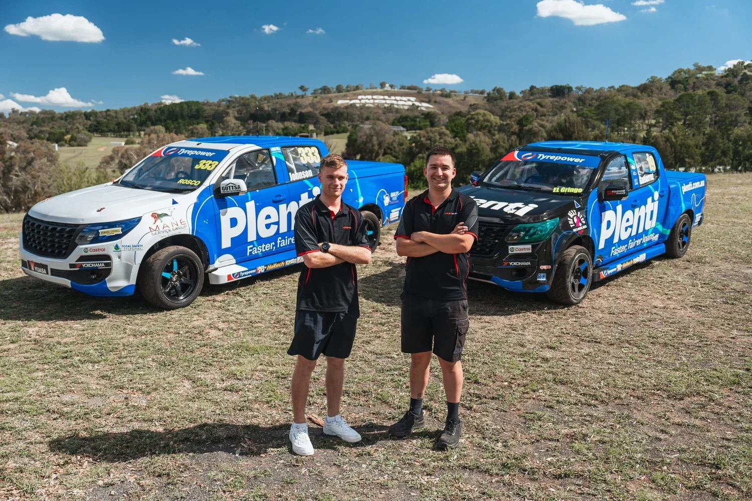 promotional photo of two V8 SuperUte Series drivers in front of their race cars at Bathurst, NSW.