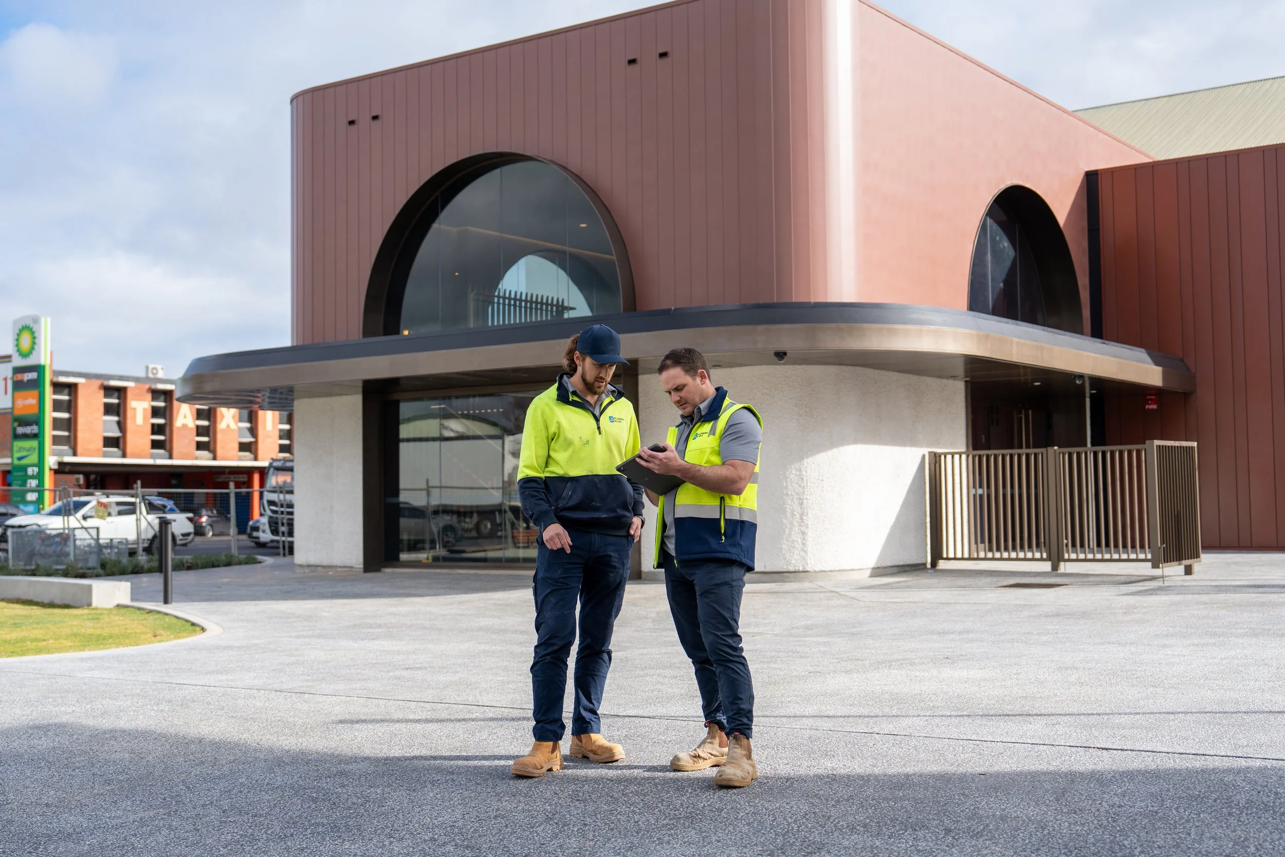 Two plumbers standing in front of the Thebarton Theatre.