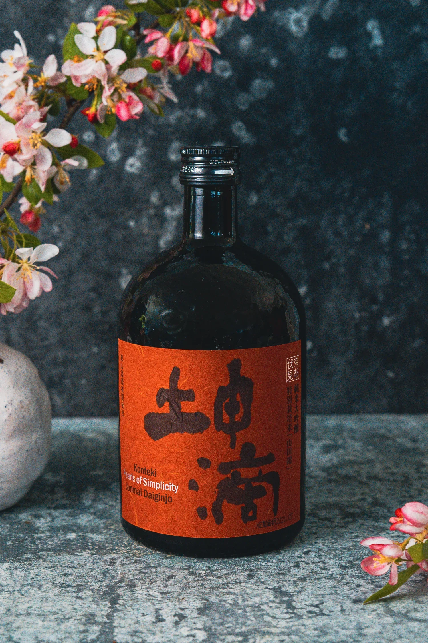 a promotional photo of a Japanese whisky in front or oriental flowers