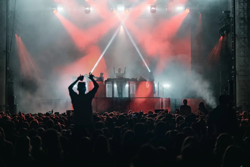 women sitting on shoulders in a crowd who are signing, smiling and dancing at a music festival in McLaren Vale, South Australia