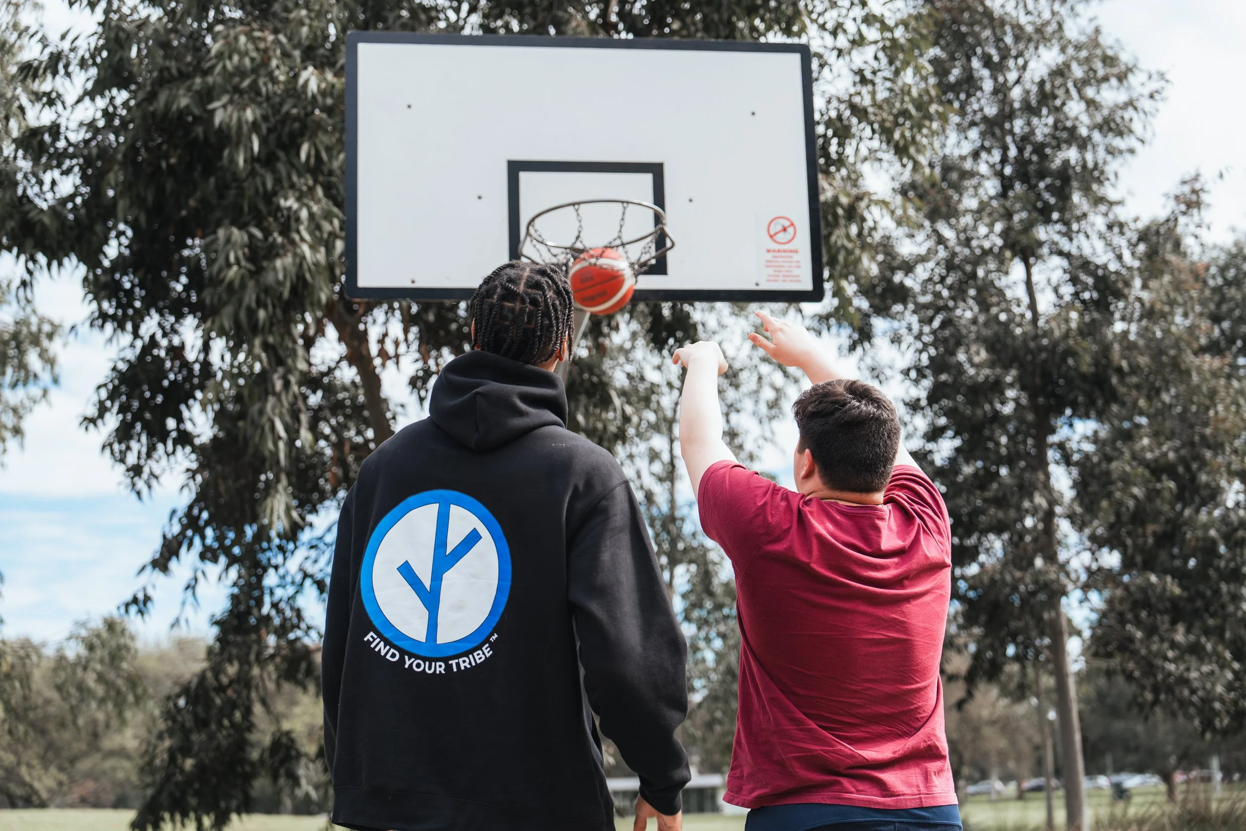 disability client playing basketball with his disability support worker