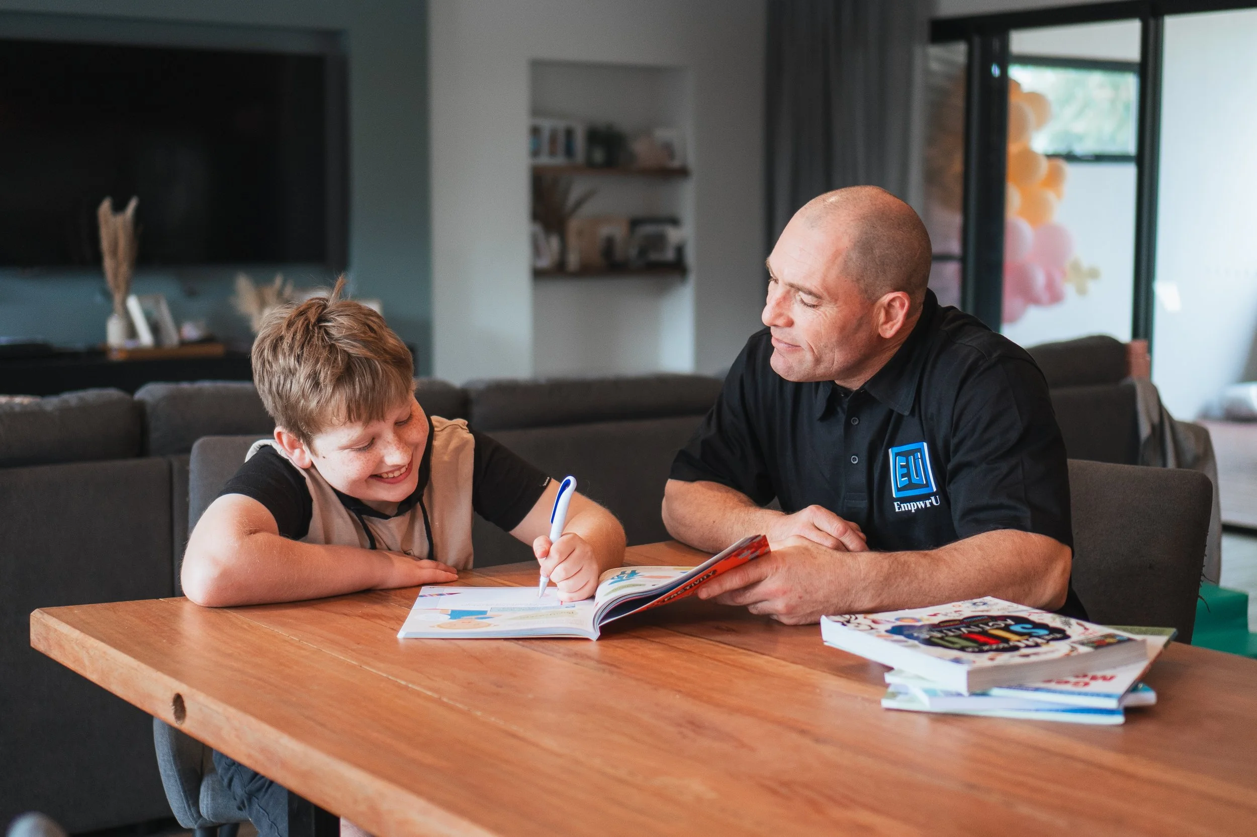 disability worker helping a young client with their school work