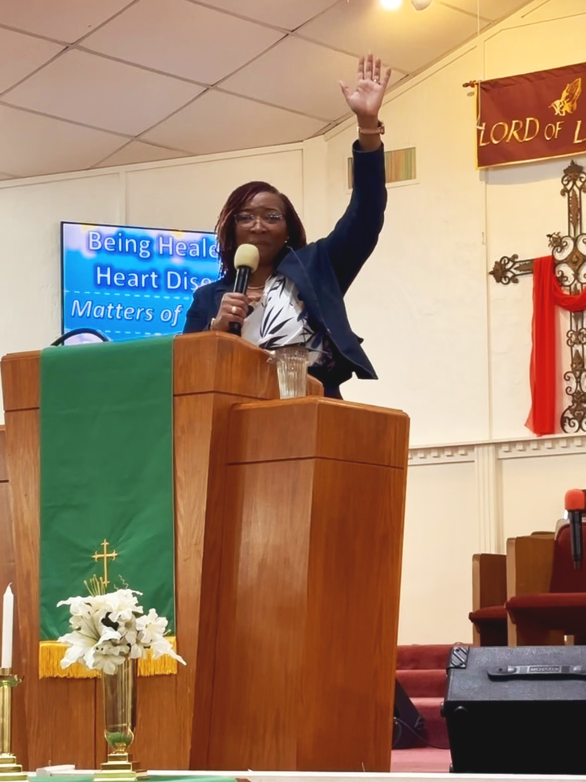 Natalie Demerson-Watkins delivering a faith-based keynote from a church pulpit, speaking on healing and resilience.