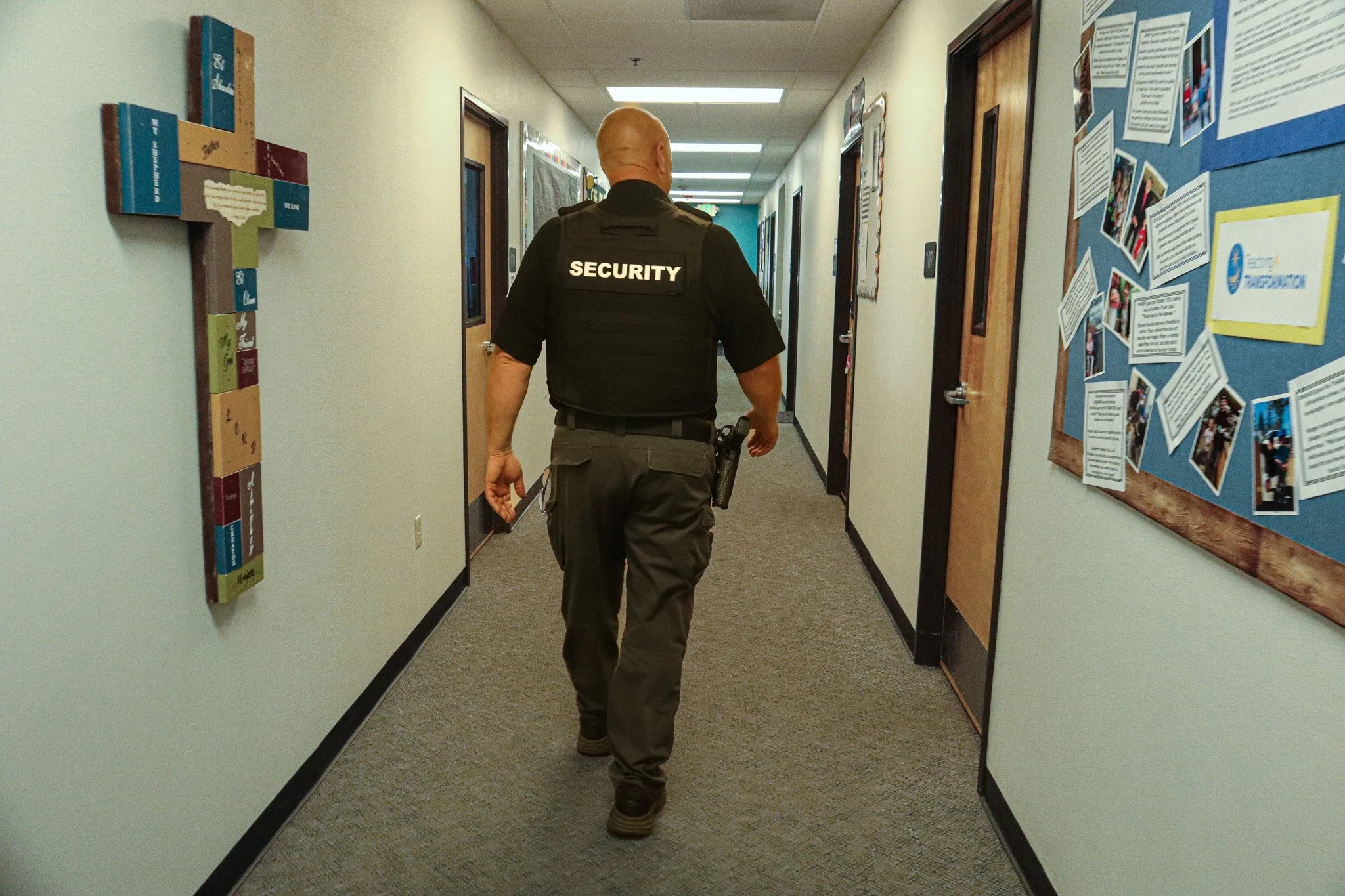 Security officer walking down a hallway in a building.