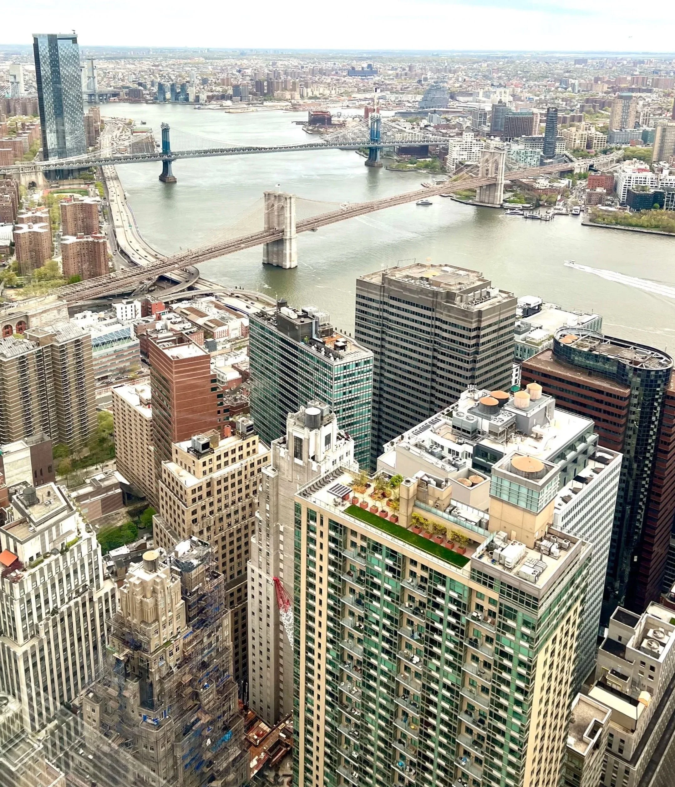 Aerial view of Manhattan skyline with skyscrapers, the Brooklyn Bridge, and the East River in New York City.