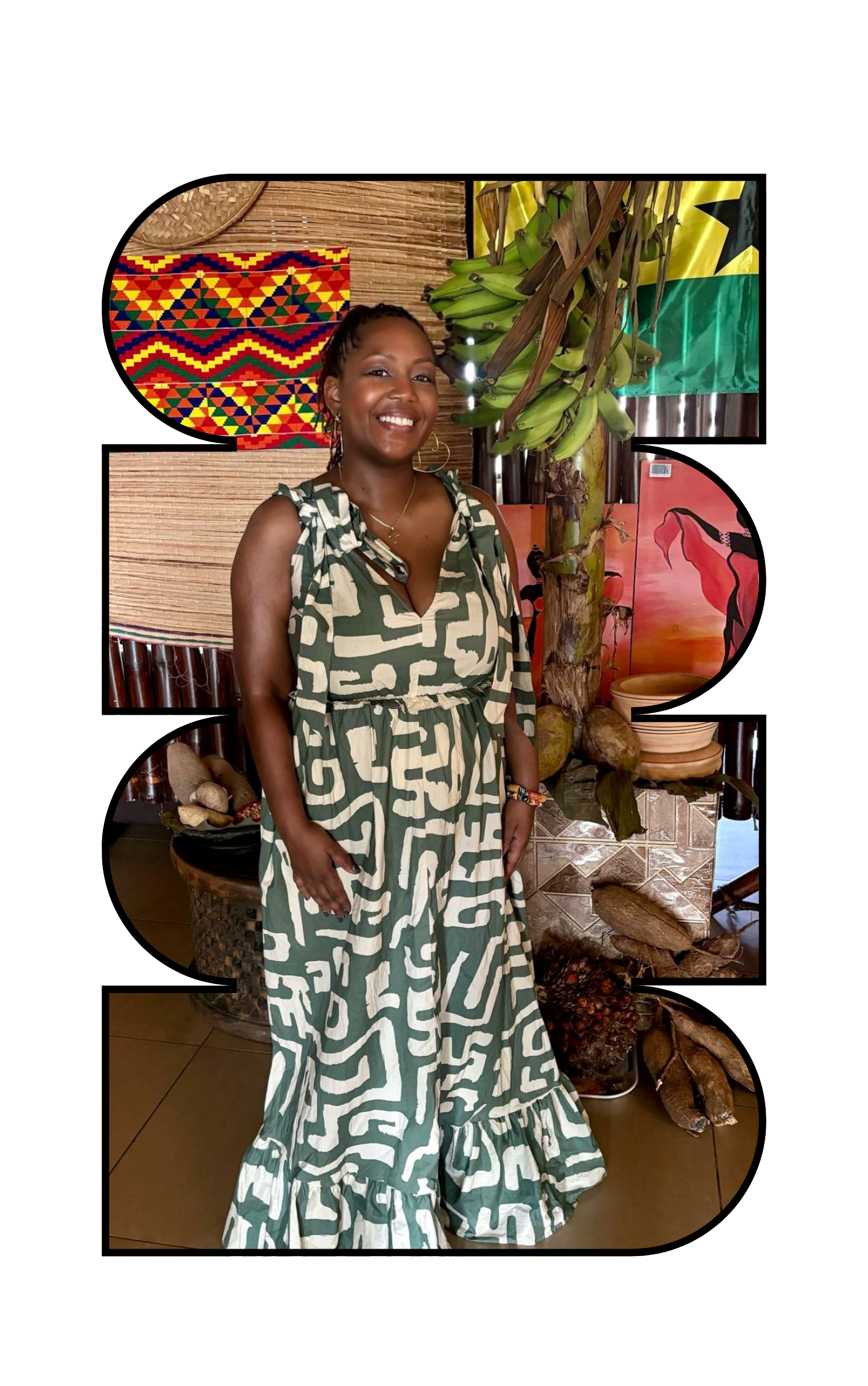 A smiling woman in a patterned green and white dress standing indoors with African art and decorations, including a banana plant, paintings, and woven wall hangings.