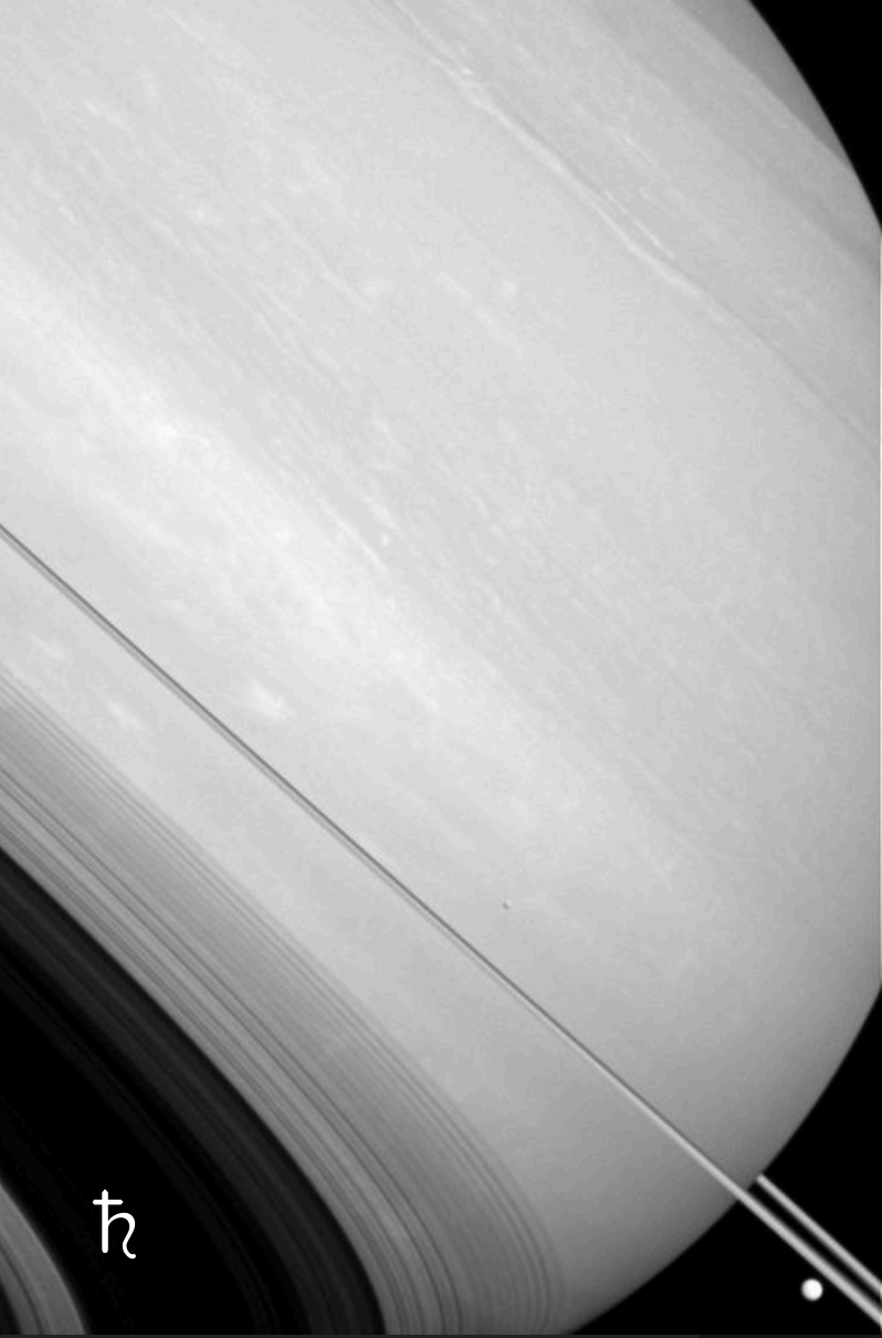 Close-up view of Saturn's rings with a small moon in the lower right edge.