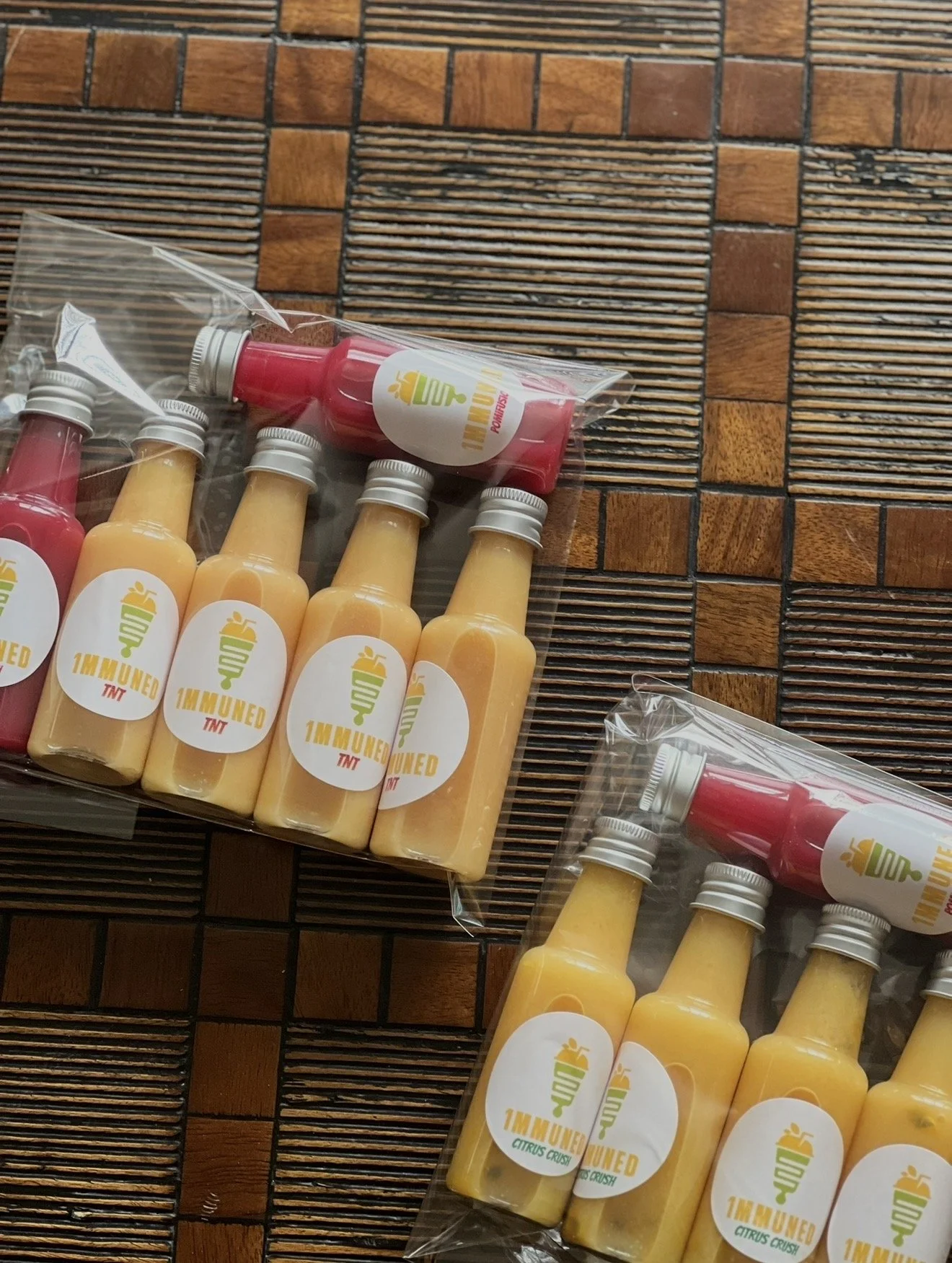 Assorted 1MMUNED immunity shots displayed on wooden surface