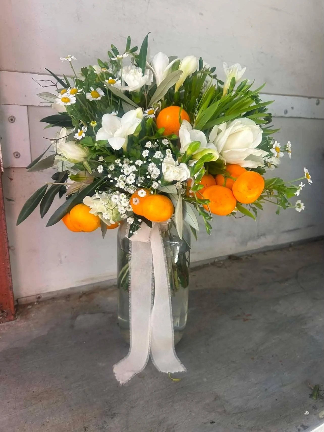 Bridal bouquet by Terrace Florist featuring white roses, seasonal greenery and citrus accents for an intimate boutique wedding in Marlborough, New Zealand.