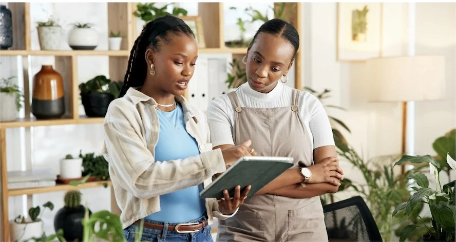 Professional home organizer reviewing household items with a client using a clipboard to assess priorities before decluttering. The Take Stock step creates a personalized organizing plan.