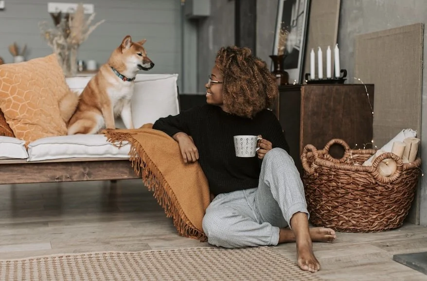 Woman sitting peacefully with a cat, taking a mindful pause before beginning the home organizing process. The S.T.I.L.L. Method™ encourages slowing down to reduce overwhelm and create intentional change.