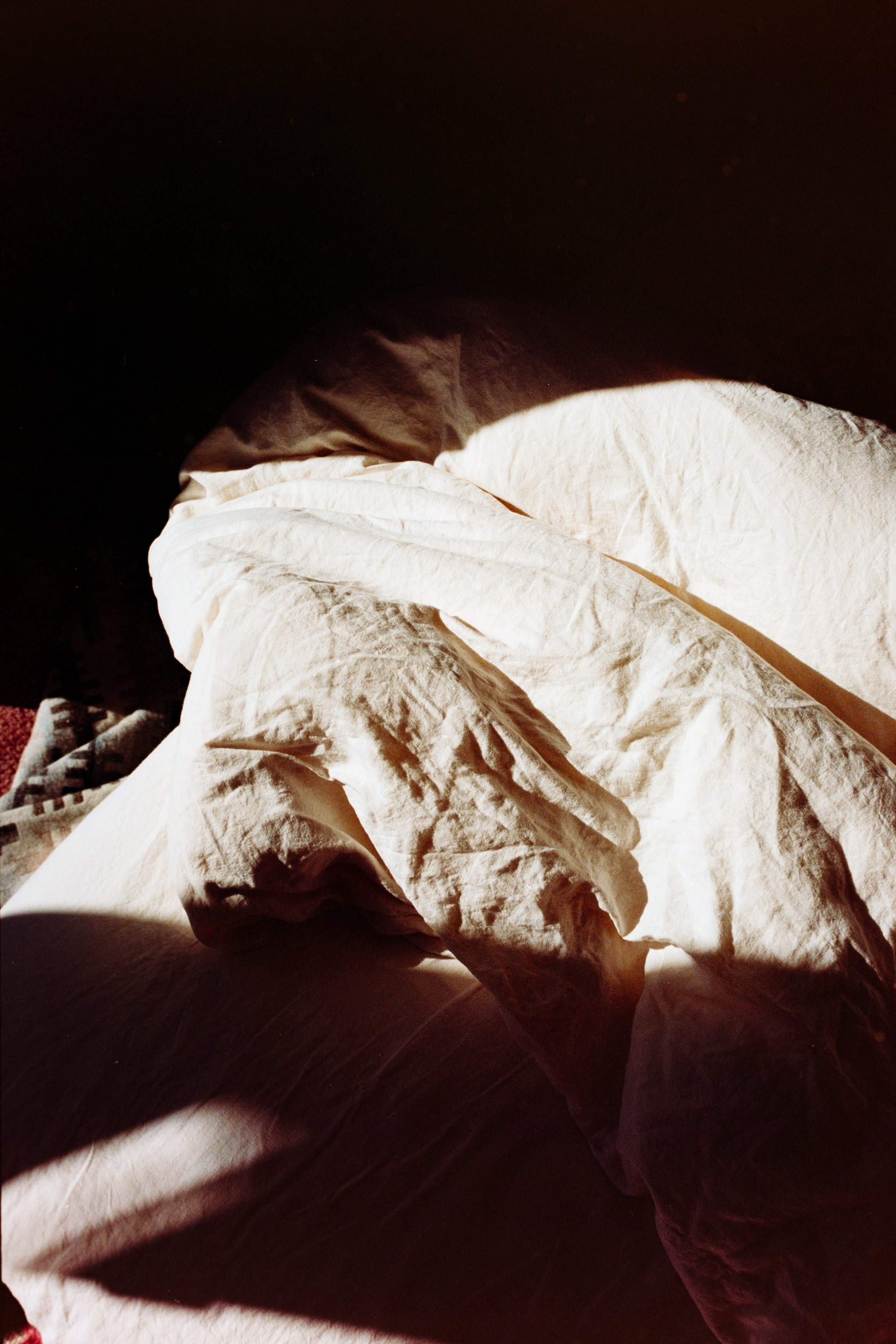Close-up of crumpled white and brown paper or cloth in sunlight with shadowed background.