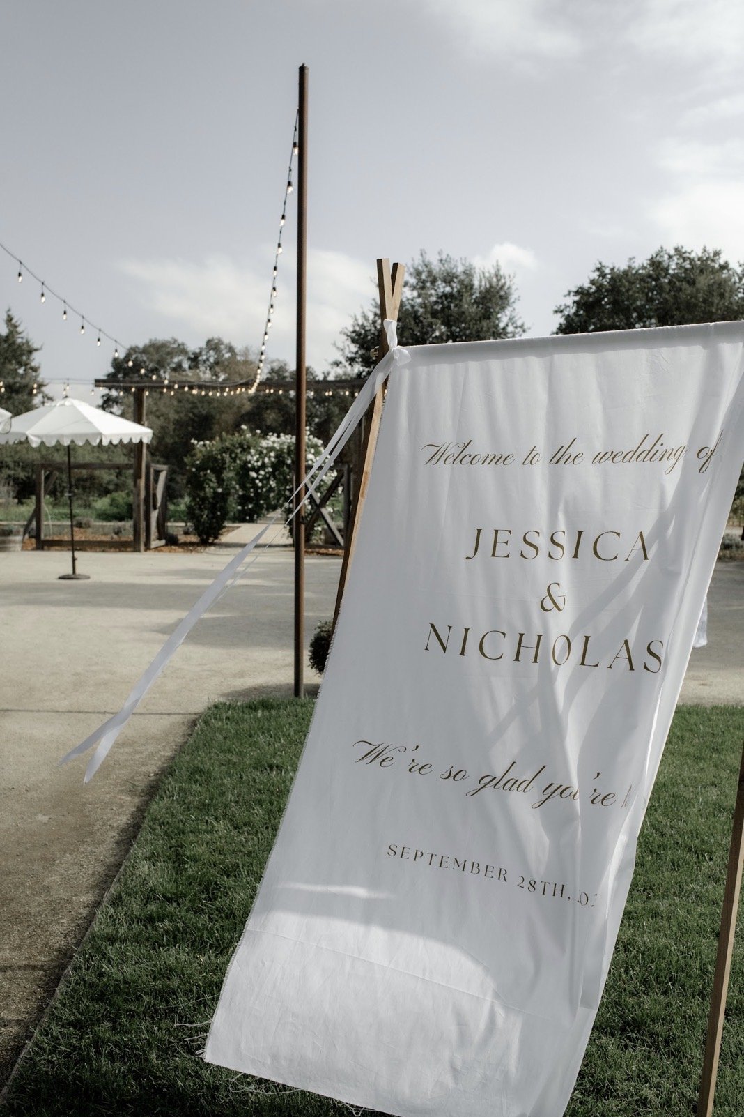 Wedding welcome sign for Jessica and Nicholas showcasing signature tone design, company branding, local embroidery craftsmanship, and a quick timeline