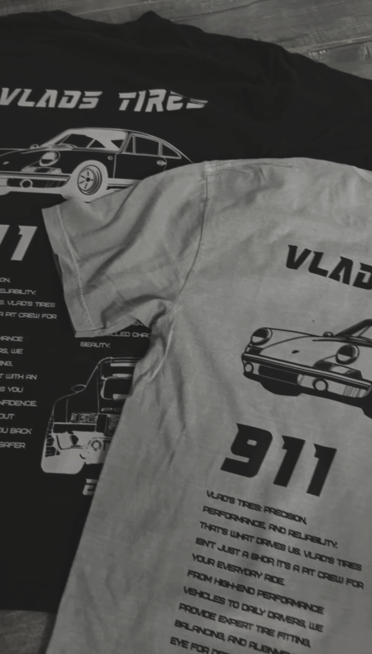 Gray t-shirt with black text and illustrations of cars, including a 911 Porsche, advertising Vulads Tires and promoting tire performance and reliability.