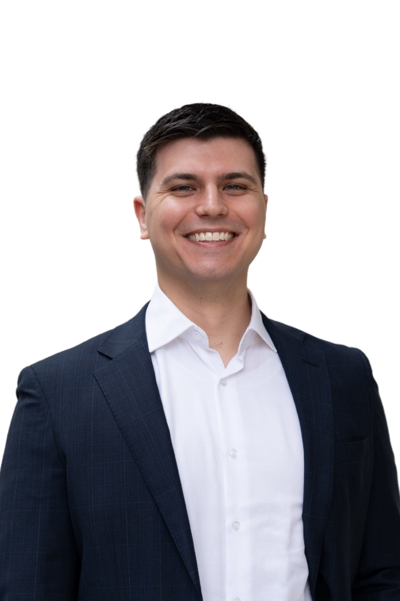 A young man in a white dress shirt and navy blazer smiling at the camera.