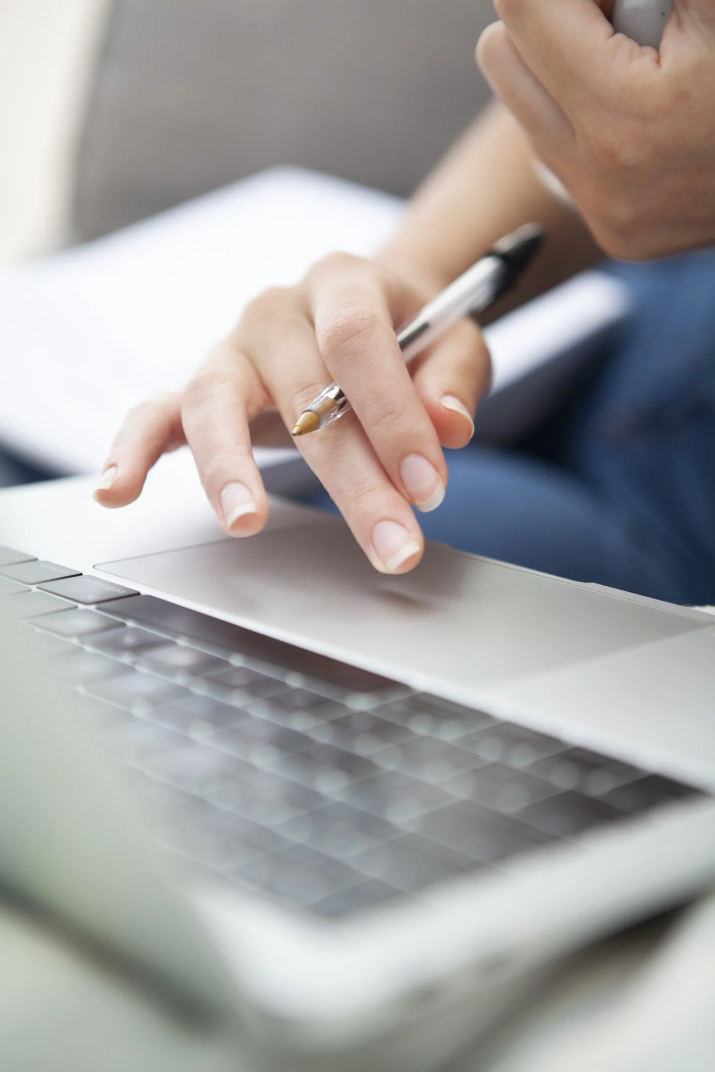 Nahaufnahme einer Hand, die mit einem Stift auf einem Laptop-Trackpad tippt.