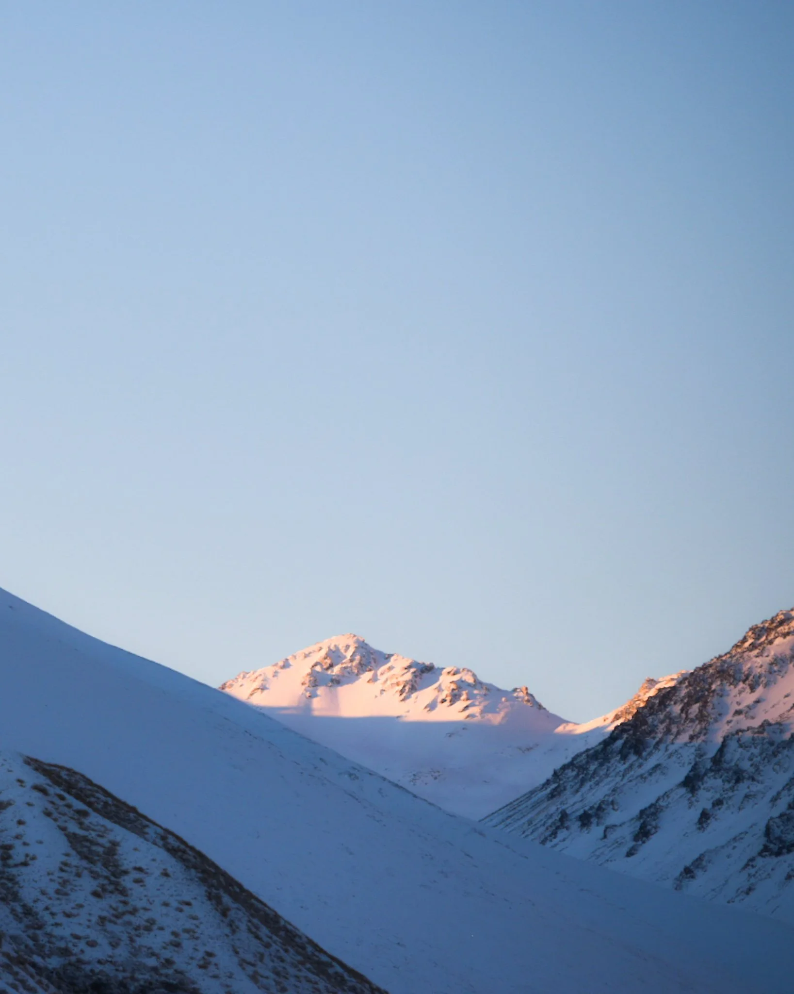 Snow-covered mountain peaks under a clear blue sky.