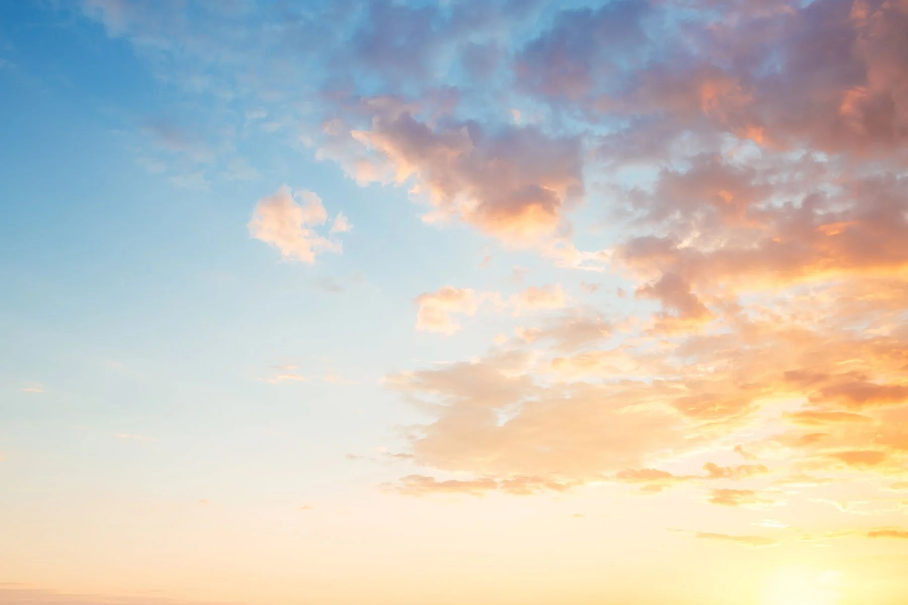 Blick auf den Himmel während des Sonnenuntergangs mit Wolken in verschiedenen Orangetönen.
