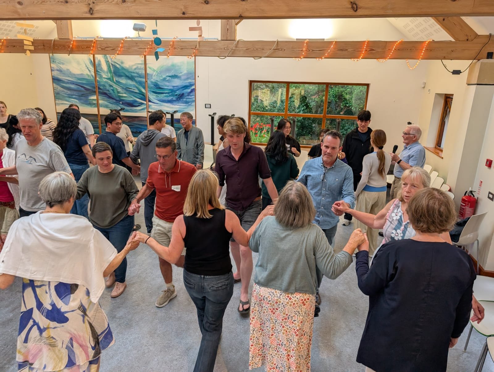 A group of people dancing in a circle at an indoor event or party.