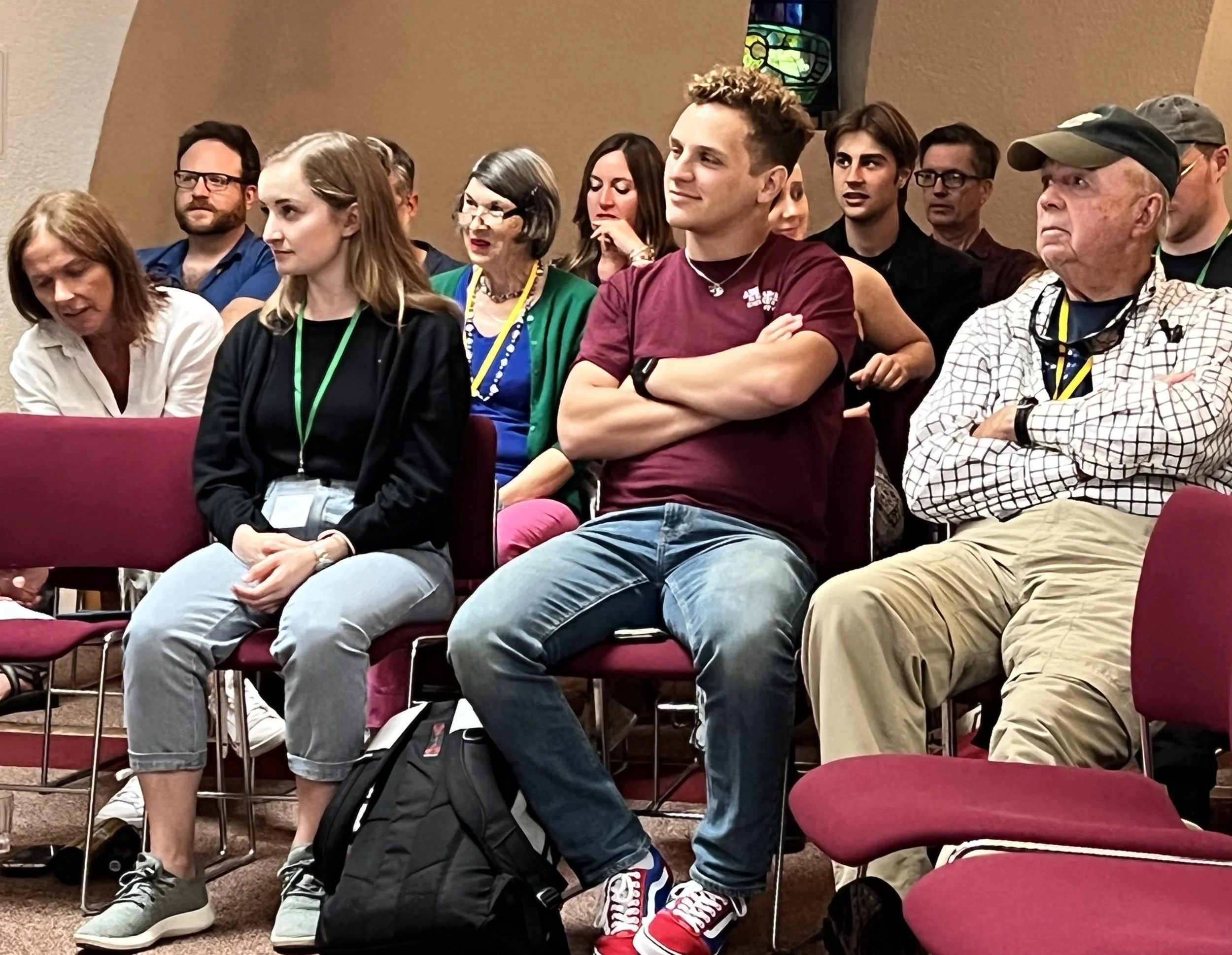 Audience of diverse adults sitting and listening at a Learning Journey conference or seminar.
