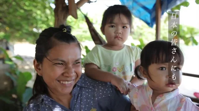 三人の子供と女性の笑顔の写真、背景は自然の緑と木陰