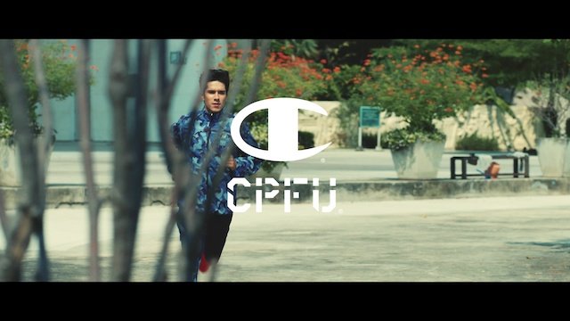 男性が公園のような場所で走っている。背景に花や木、ベンチが見える。