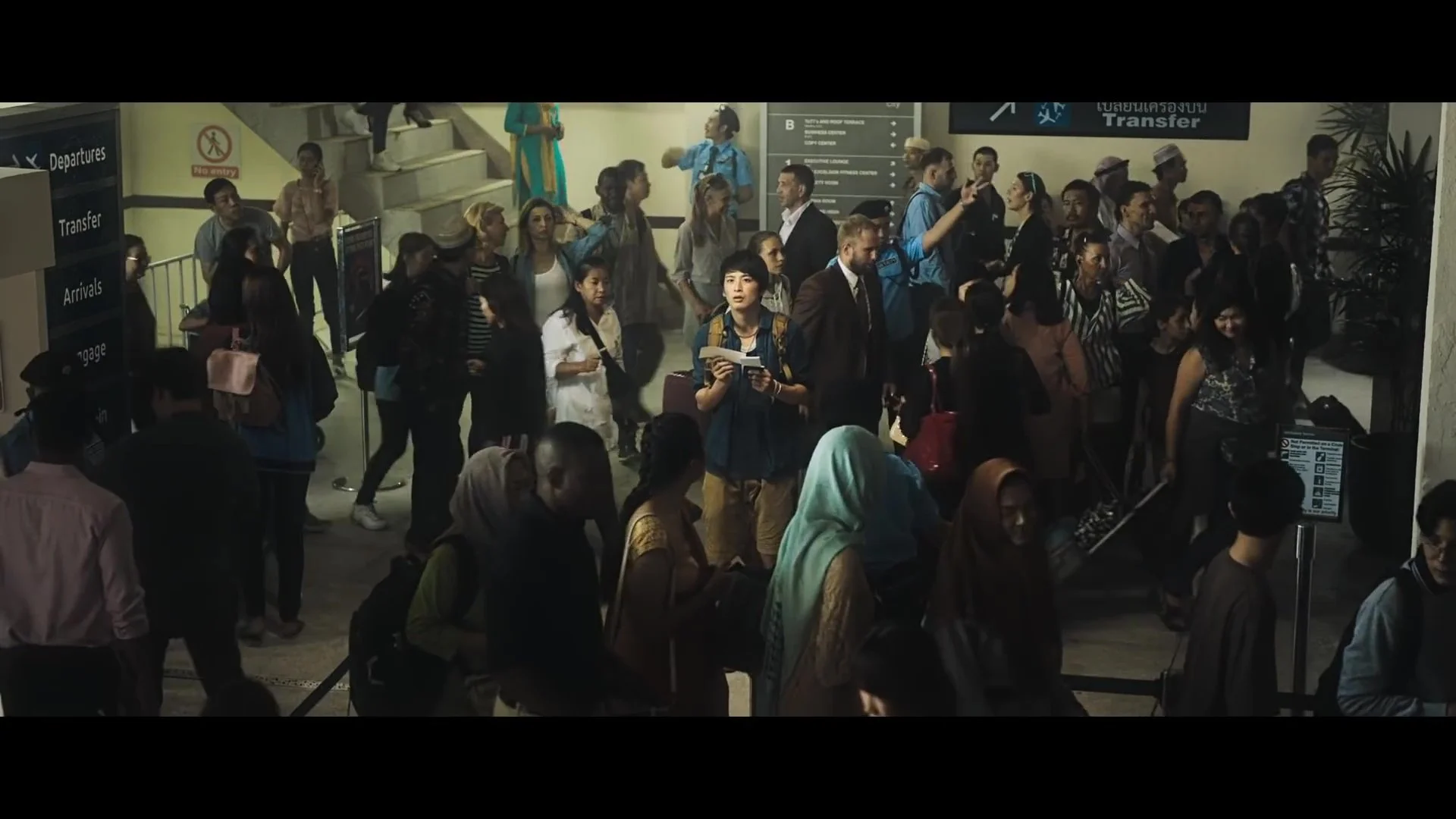 空港の到着エリアの混雑した人々の待ち行列と案内板