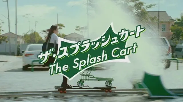 女性がスケートボードでスプラッシュカートの看板の前を通過しているシーン