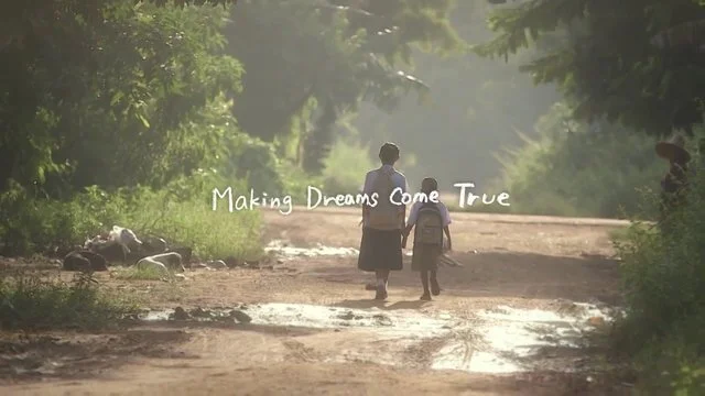 森の中の道を歩く女性と子供のシルエット。夕焼けの光が二人を照らしている。