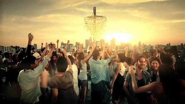 サンセットの背景の屋上で多くの人々が踊りながら楽しんでいるパーティー風景