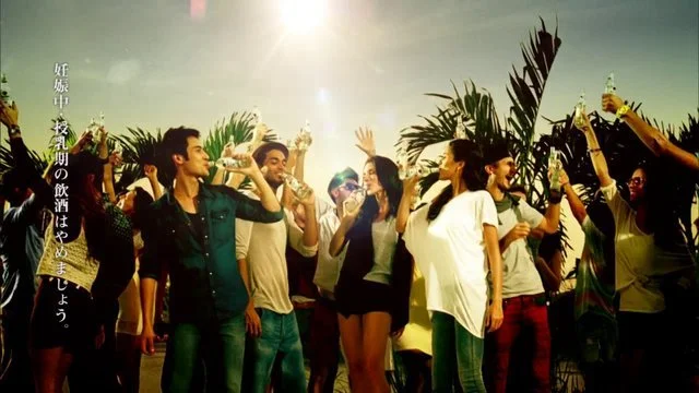 夕暮れの屋外で複数の若者が踊りながら手を振っているグループ写真.