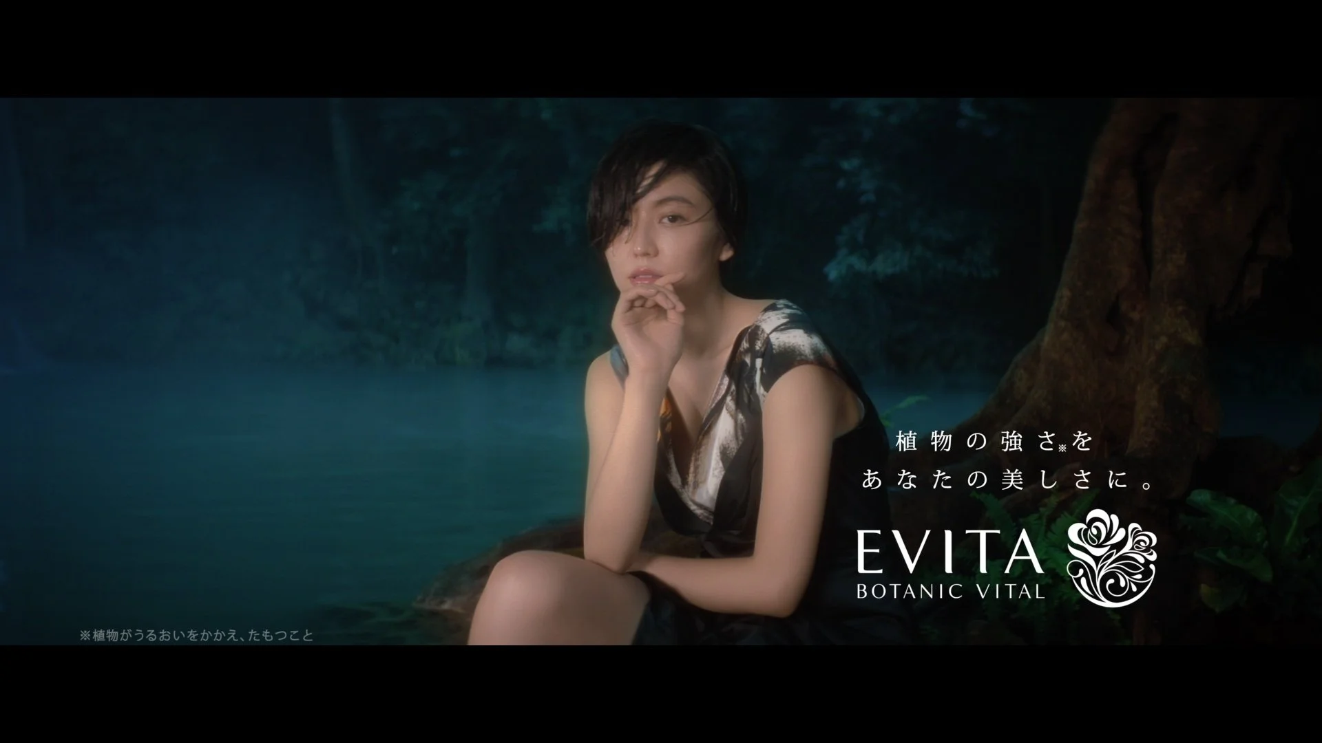 森の中の温泉に座る女性の写真。