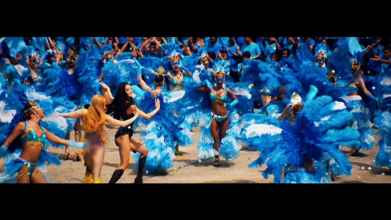 青色の衣装を着たダンサーたちがビーチで踊っているカーニバルの風景