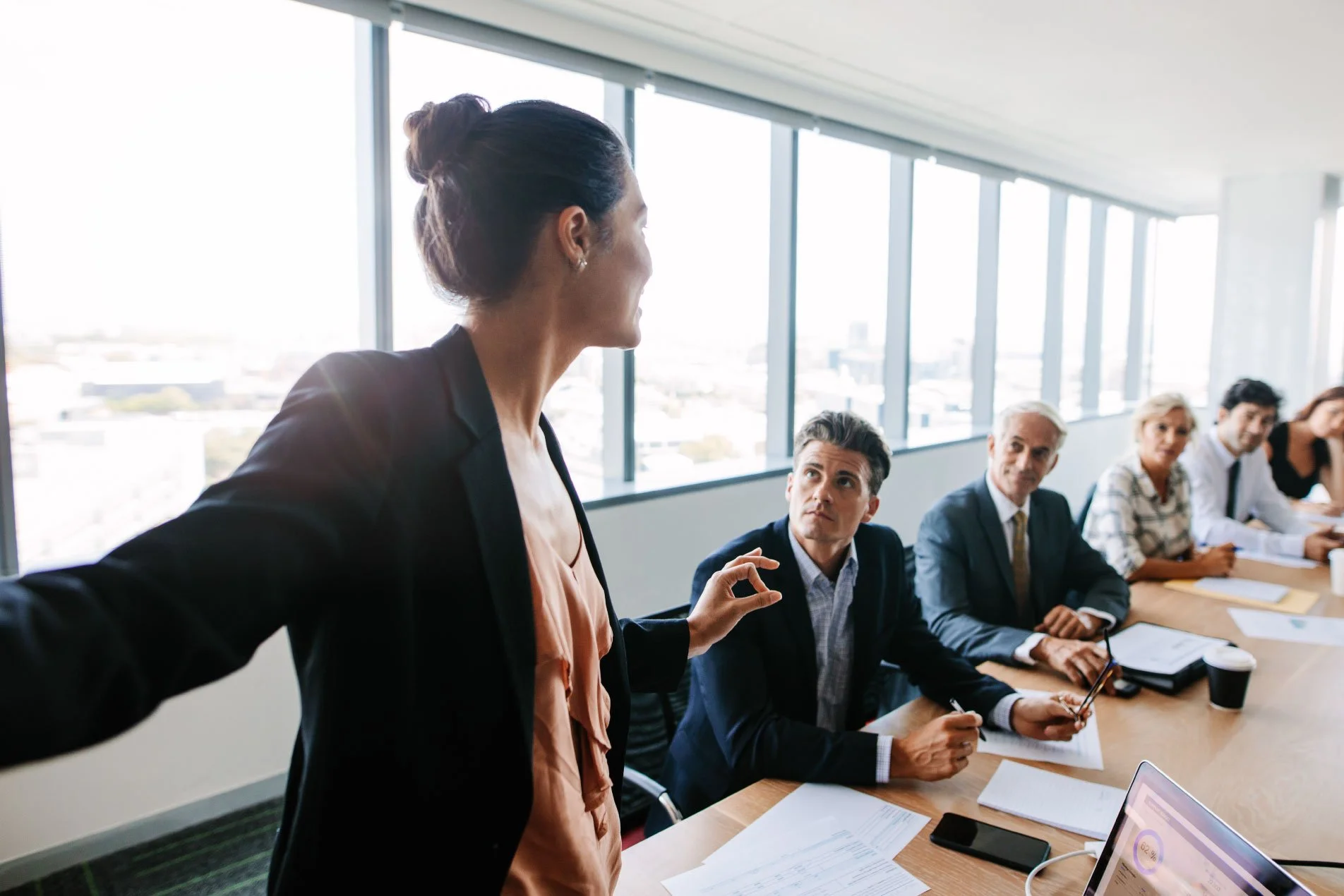 Female project manager leading a team meeting, discussing plans with colleagues around a table