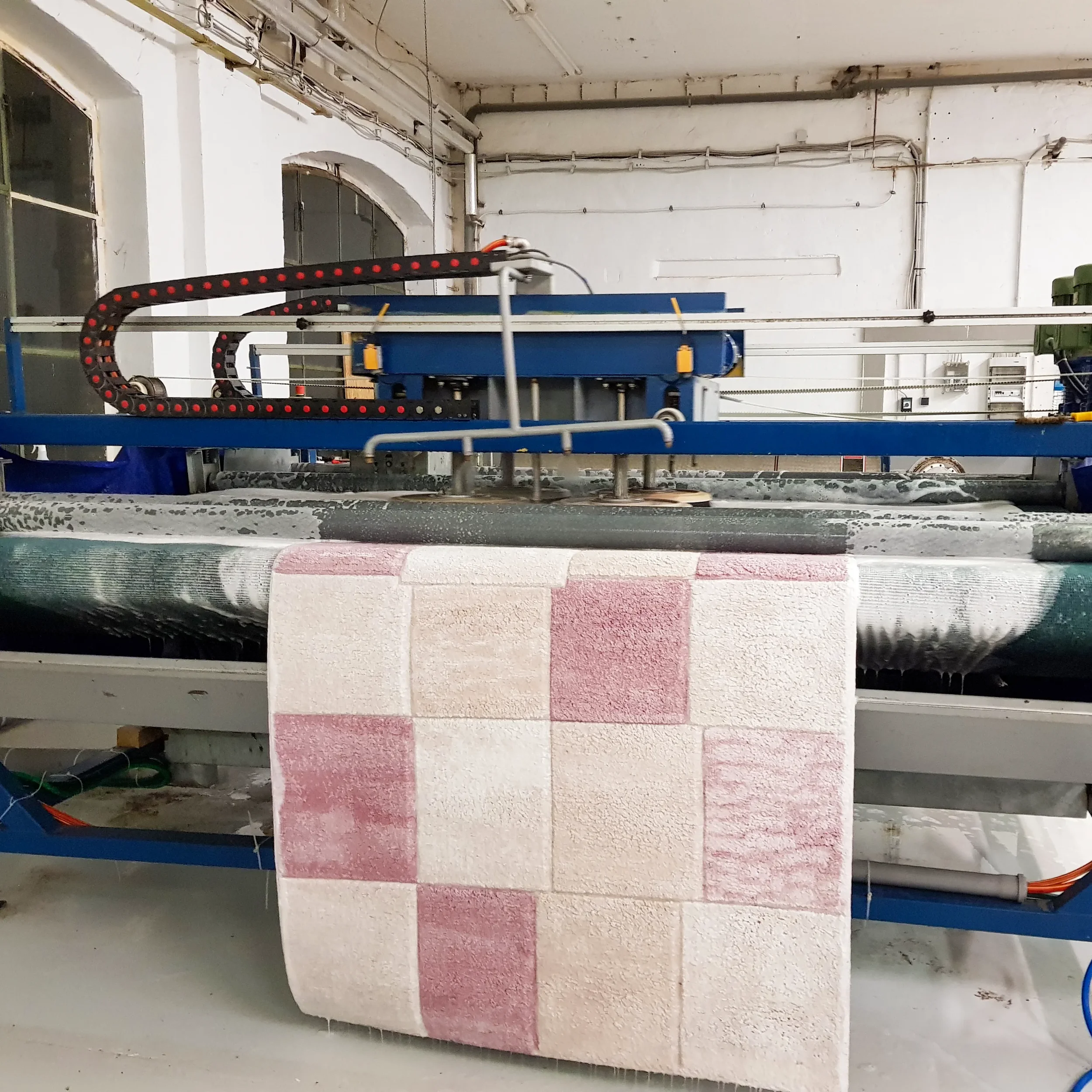 Automatisiertes Mauerwerksherstellungssystem, das Wandplatten mit roten und weißen Steinen produziert.