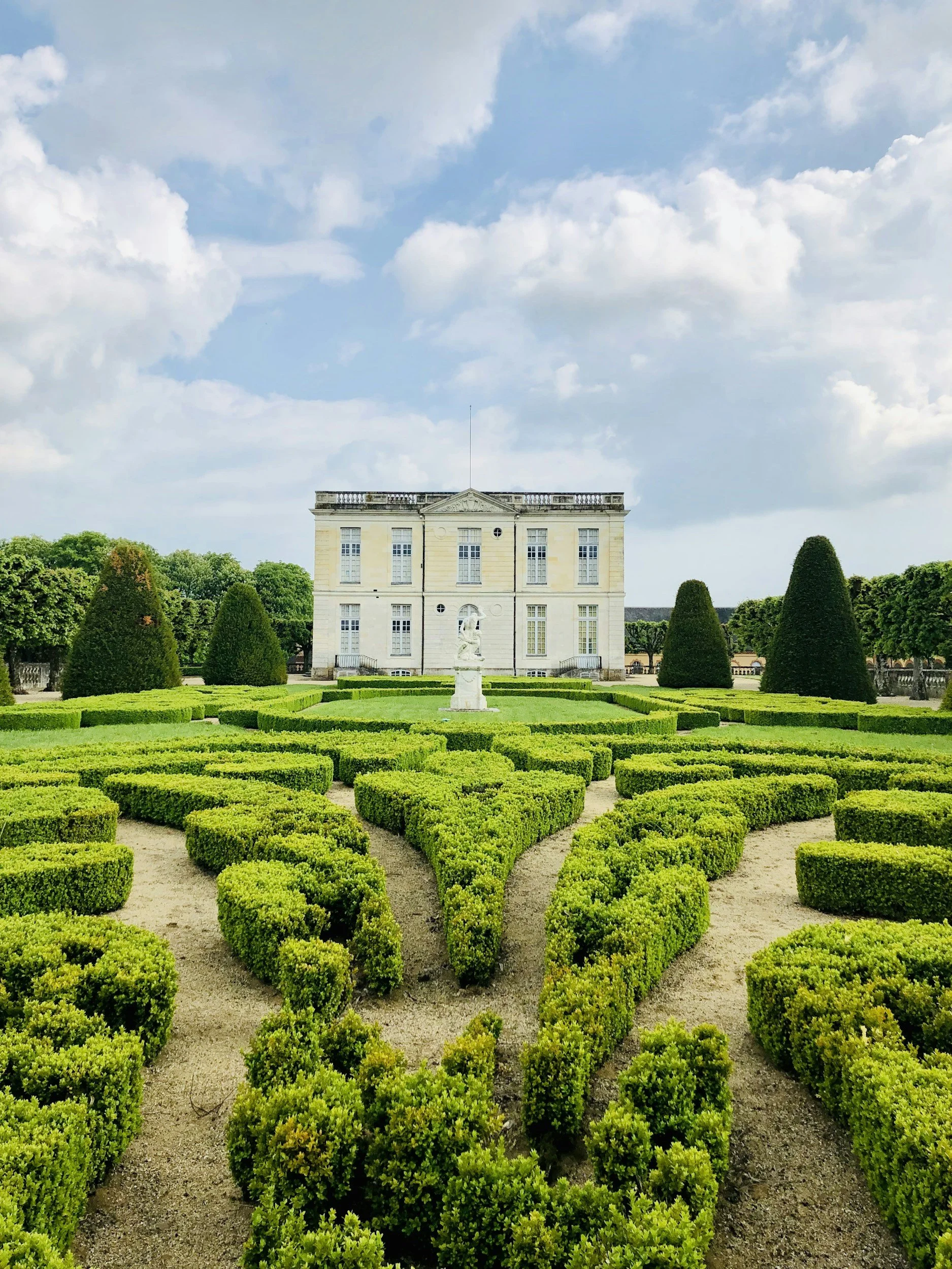 Pretty yellow château set with manicured gardens