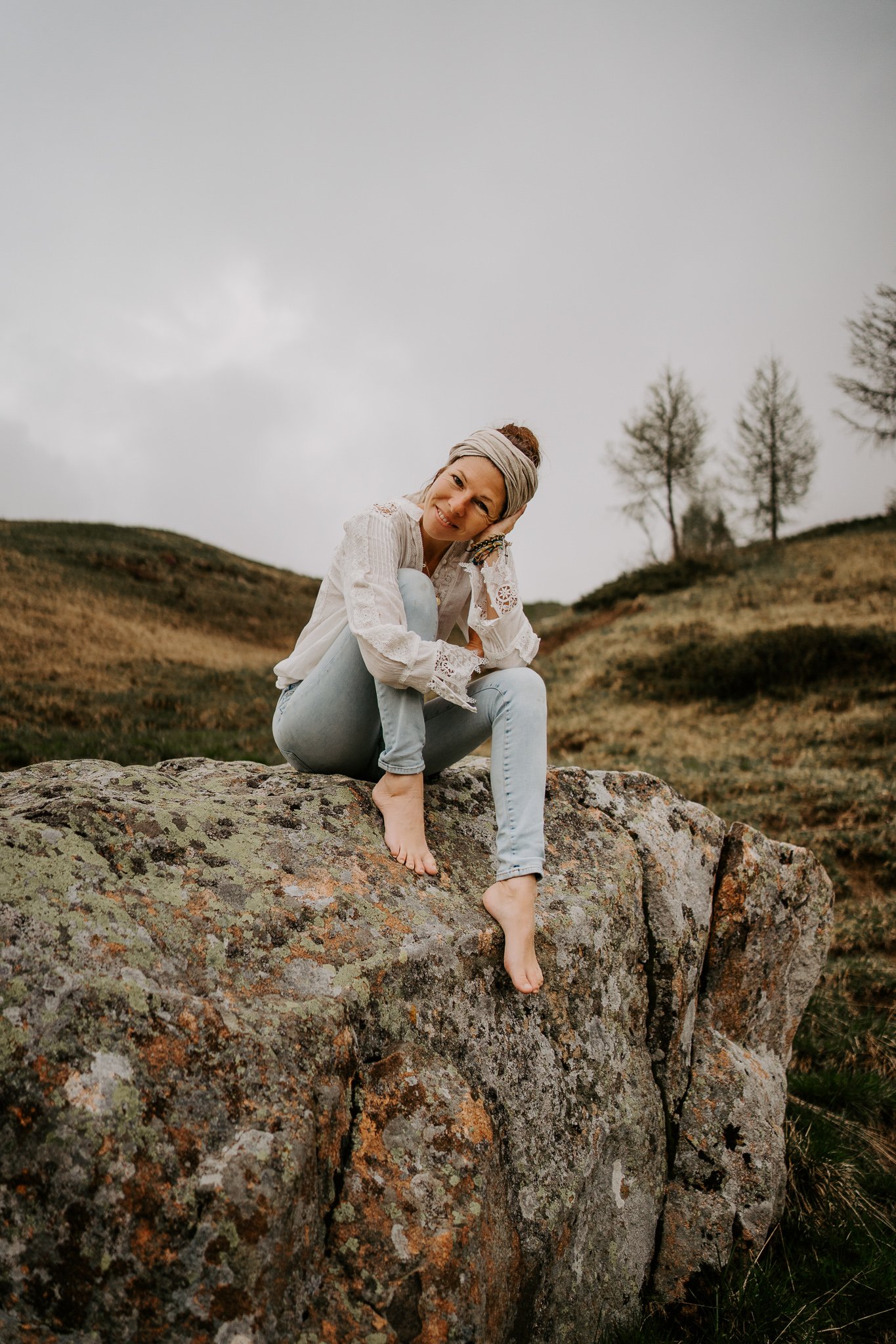 Premium Photographer in Zurich, sitting on rock and smiling into camera