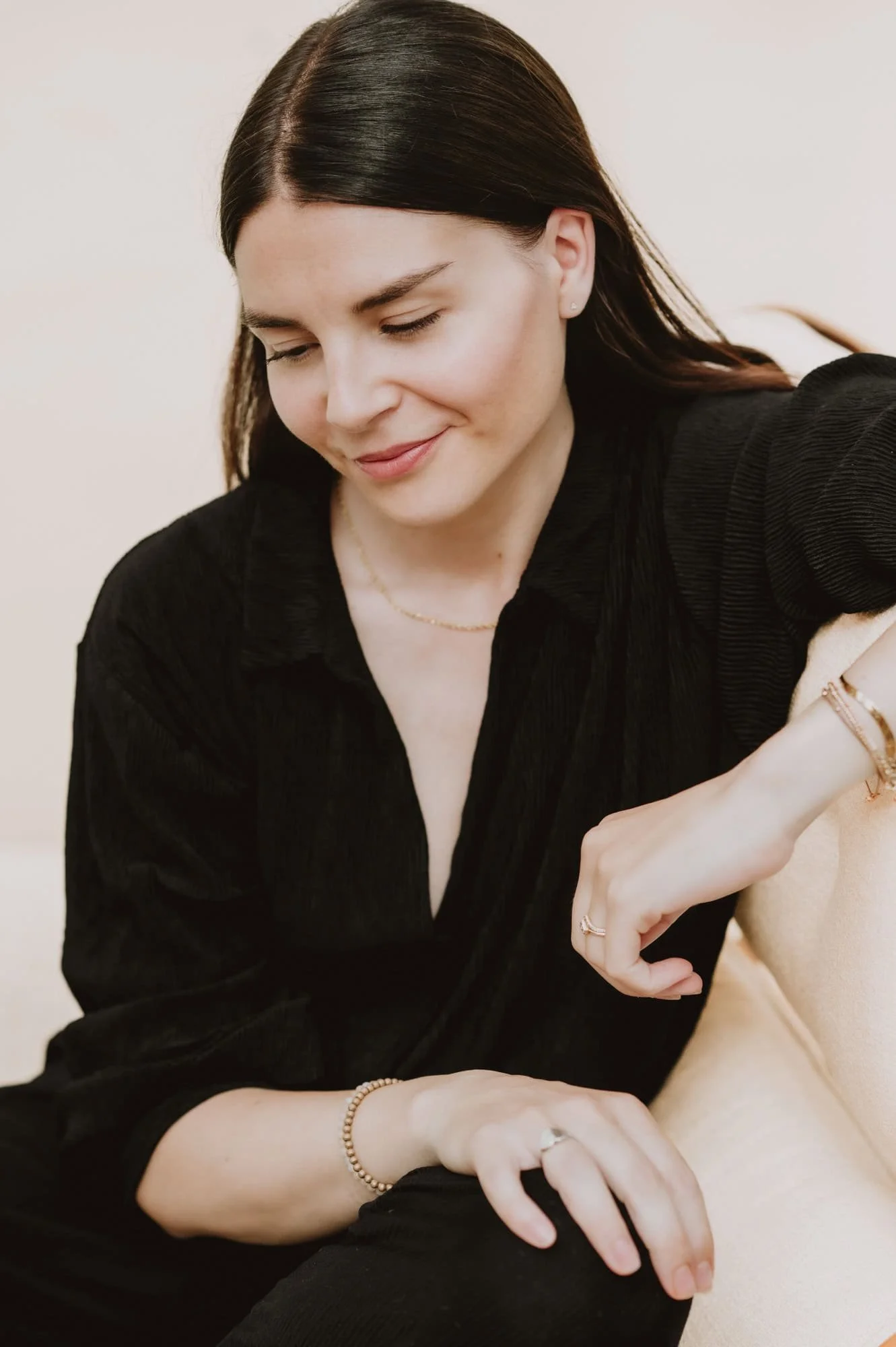 Small business owner sitting on chair wearing black outfit for business portrait in Zurich